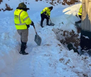 Snow crew in high-visibility gear working through a storm