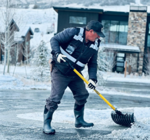 Crew member shoveling snow from a front walkway