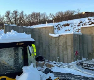 Loader moving piled snow away from a building