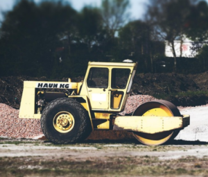 Roller compactor leveling soil during site grading