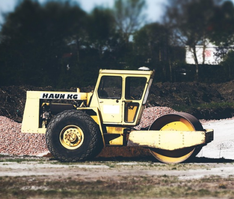 Roller compactor leveling soil during site grading