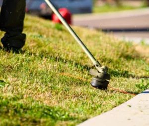 String trimmer edging grass along a walkway