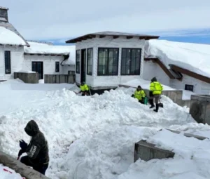 Prime Landscaping crew clearing snow around a home after a storm