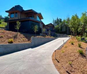 Clean concrete driveway leading to a mountain home