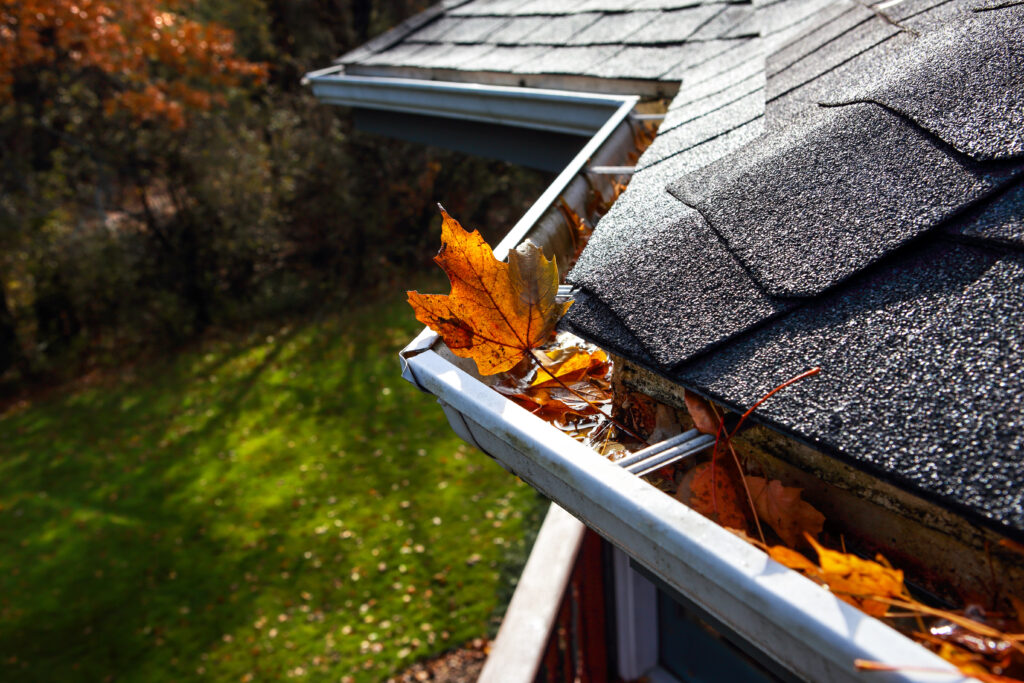 Cleaning leaves from gutters in the fall
